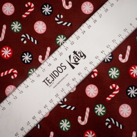 Popelín navideño rojo con bastones de caramelo y bolas navideñas