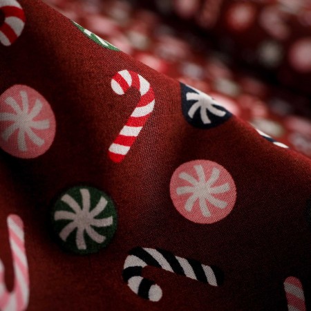 Popelín navideño rojo con bastones de caramelo y bolas navideñas